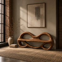 Wood bench with two looped openings above a flat plank seat in an industrial loft entryway with exposed brick