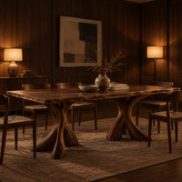 Rectangular dining table on two flared twisting pedestal bases in an evening dining room with walnut wall paneling