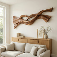 Twin strand wooden wall art with an eye shaped opening above a light oak sideboard in daylight