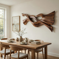 Twin strand wooden wall art with an eye shaped opening beside a dining table in natural light