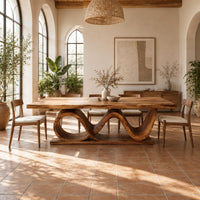 Dining table with a slab top on a twin wave ribbon base in a bright dining room with arched windows and plants