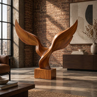 Twin wing sculpture with swept tips rising from a square wooden block in an industrial loft living room with exposed brick