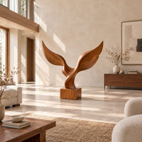 Twin wing sculpture with swept tips rising from a square wooden block in a bright open plan living room