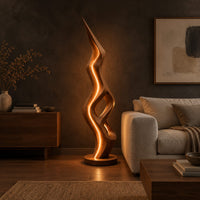 Tall floor lamp with a pointed tip, open twisting body and glowing edges in a dark living room at golden hour