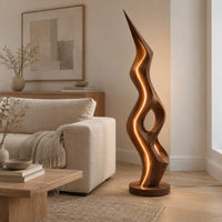 Tall floor lamp with a pointed tip, open twisting body and glowing edges in a Scandinavian living room with white walls