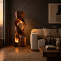 Twisted wooden block floor lamp with an oval window and glowing base opening in a dark living room at golden hour