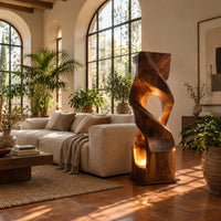 Twisted wooden block floor lamp with an oval window and glowing base opening in a bright living room with arched windows and plants