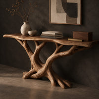 Corner detail of console table with twisting branch legs, root like feet and a live edge top beside wood, brass and linen samples