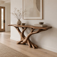 Console table with twisting branch legs, root like feet and a live edge top in a Scandinavian entryway with white walls
