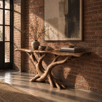 Console table with twisting branch legs, root like feet and a live edge top in an industrial loft entryway with exposed brick
