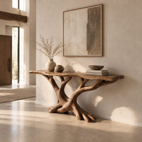 Console table with twisting branch legs, root like feet and a live edge top in a bright open plan entryway