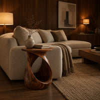 Twisted side table with a circular top and open loop base in an evening living room with walnut wall paneling