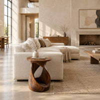 Twisted side table with a circular top and open loop base in a bright open plan living room