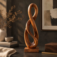 Corner detail of twisted figure eight wood sculpture with two open loops on a block base beside wood, brass and linen samples