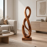 Twisted figure eight wood sculpture with two open loops on a block base in a Scandinavian living room with white walls