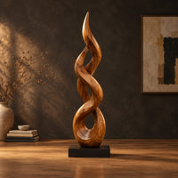Twisted flame shaped sculpture with open loops rising to a pointed tip in a dark studio against a charcoal plaster wall