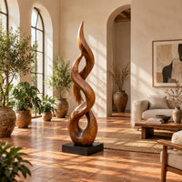 Twisted flame shaped sculpture with open loops rising to a pointed tip in a bright living room with arched windows and plants