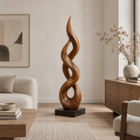 Twisted flame shaped sculpture with open loops rising to a pointed tip in a Scandinavian living room with white walls