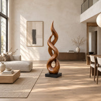 Twisted flame shaped sculpture with open loops rising to a pointed tip in a bright open plan living room