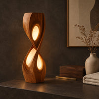 Corner detail of tall twisted floor lamp with two teardrop openings that glow beside wood, brass and linen samples