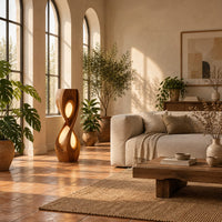 Tall twisted floor lamp with two teardrop openings that glow in a bright living room with arched windows and plants