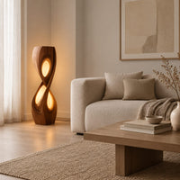 Tall twisted floor lamp with two teardrop openings that glow in a Scandinavian living room with white walls