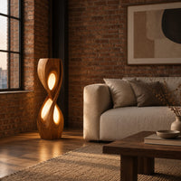 Tall twisted floor lamp with two teardrop openings that glow in an industrial loft living room with exposed brick