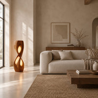 Tall twisted floor lamp with two teardrop openings that glow in a bright open plan living room