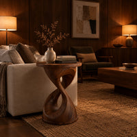 Twisted hourglass side table with a thin flat top and open waist in an evening living room with walnut wall paneling