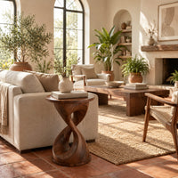 Twisted hourglass side table with a thin flat top and open waist in a bright living room with arched windows and plants