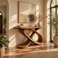 Console table with a twisted loop base and a slim oval top in a bright entryway with arched windows and plants