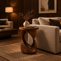 Side table with a circular top on a twisted open loop base in an evening living room with walnut wall paneling