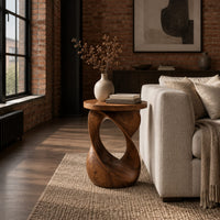 Side table with a circular top on a twisted open loop base in an industrial loft living room with exposed brick