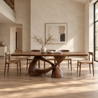 Dining table with a rectangular top on a twisted loop pedestal in a bright open plan dining room