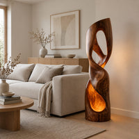 Twisted floor lamp with open loops and a glowing hollow base in a Scandinavian living room with white walls