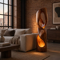 Twisted floor lamp with open loops and a glowing hollow base in an industrial loft living room with exposed brick