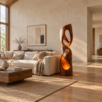 Twisted floor lamp with open loops and a glowing hollow base in a bright open plan living room