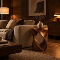 Twisted hourglass side table with an open loop through its body in an evening living room with walnut wall paneling