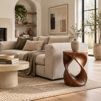 Twisted hourglass side table with an open loop through its body in a Scandinavian living room with white walls