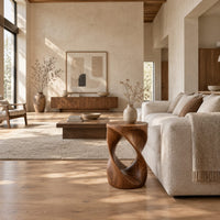 Twisted hourglass side table with an open loop through its body in a bright open plan living room