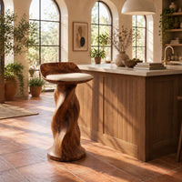 Bar stool with a twisted pedestal, a flared foot and a scooped wood seat in a bright kitchen with arched windows and plants