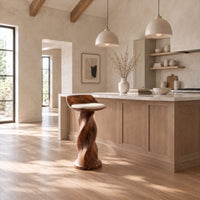 Bar stool with a twisted pedestal, a flared foot and a scooped wood seat in a bright open plan kitchen