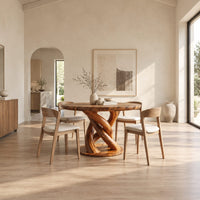 Circular wooden dining table with a twisting braided pedestal on a disc base in a bright open plan dining room