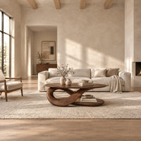 Oval coffee table on a twisted ribbon base with a flat oval shelf below in a bright open plan living room