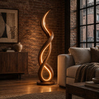 Floor lamp of twisting wooden ribbon with a glowing loop at the base in an industrial loft living room with exposed brick