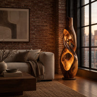 Floor lamp shaped as a twisting vase with open ribbon cutouts that glow in an industrial loft living room with exposed brick