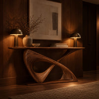 Sculptural console table with a twisted ribbon loop base and slim top in an evening entryway with walnut wall paneling