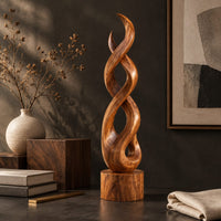 Corner detail of twisted wood sculpture of intertwined ribbons on a short cylinder base beside wood, brass and linen samples