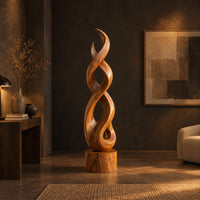 Twisted wood sculpture of intertwined ribbons on a short cylinder base in a dark living room at golden hour