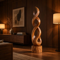 Twisted wood sculpture of intertwined ribbons on a short cylinder base in an evening living room with walnut wall paneling